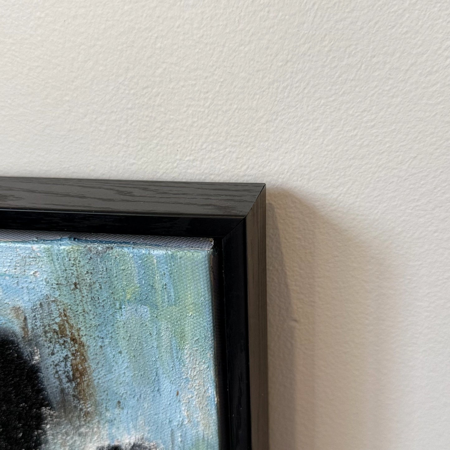 Corner detail of Blue Ink textured painting in a black wood finish frame