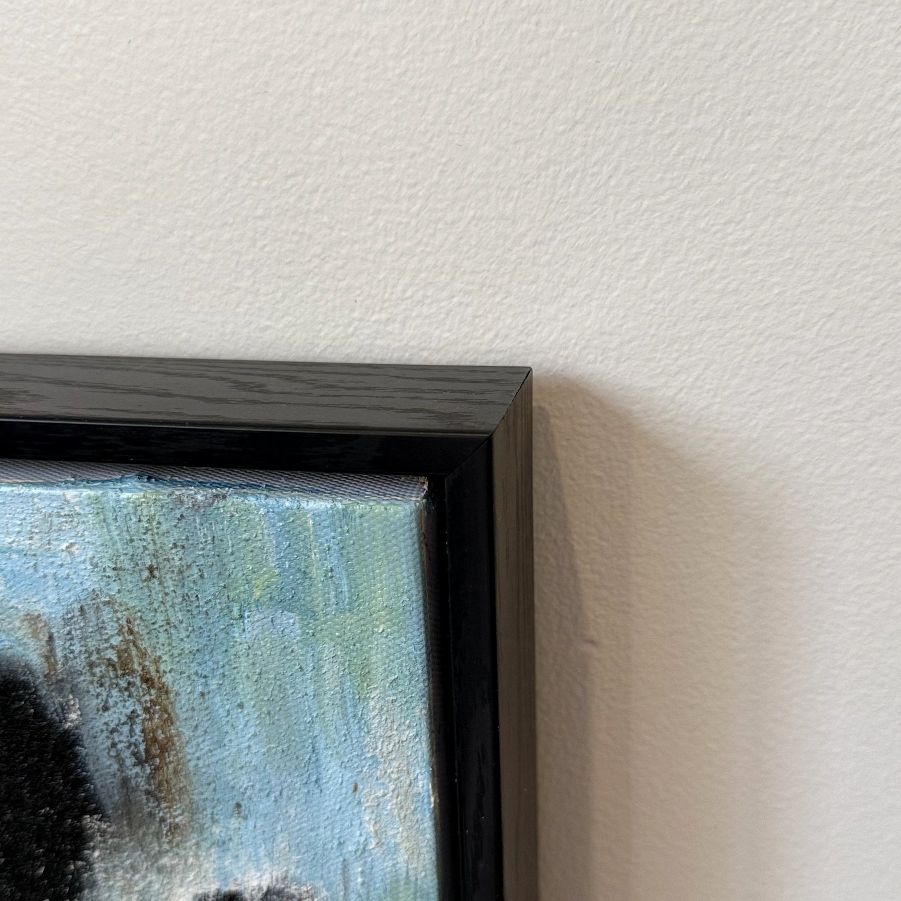 Corner detail of Blue Ink textured painting in a black wood finish frame
