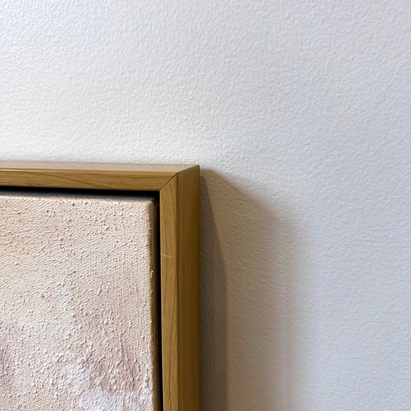 Corner detail of Gilded Shore textured painting in a nature wood finish frame