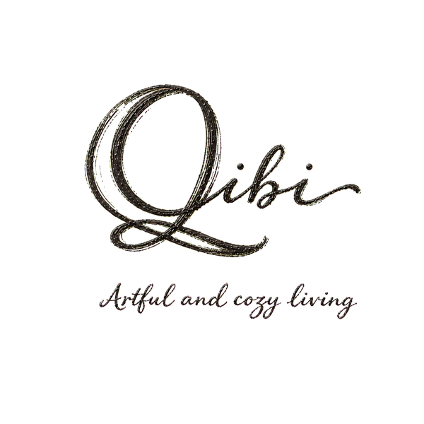 A black cursive logo reading 'Qibi' with the phrase 'Artful and cozy living' underneath, centered on a plain white background.